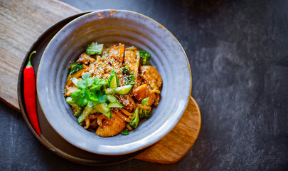 A bowl of udon with chicken and broccoli