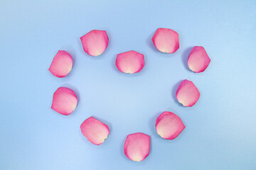 Fototapeta premium Heart shape from roses on blue background. Holiday, Valentine's, International Women's day. Copy space