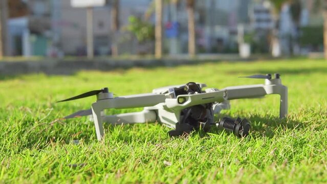 Accident with a drone. Damaged quadcopter falls on green grass