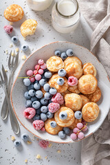 Delicious poffertjes with yoghurt and frozen berries.