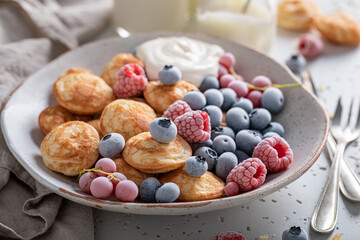 Yummy mini pancakes with frozen blueberries and raspberries.