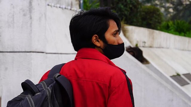 Young boy going at bus stand for bus wearing Covid mask