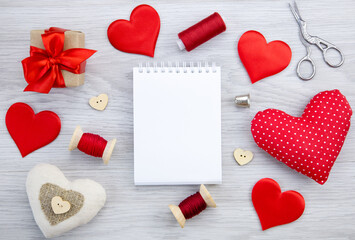 Fototapeta premium Spools of thread on the table.Sewing accessories.A white notebook for writing. The concept of love, Valentine's day,hobby