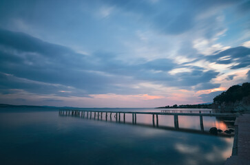 Obraz premium pier solo rock after sunset blue hours long exposure