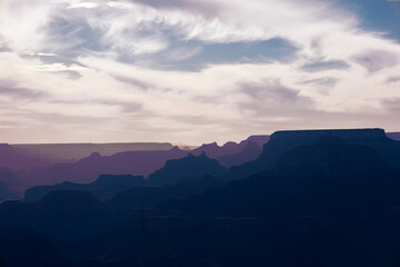 Purple desert mountains against a cloudy sky of cirrus clouds