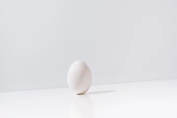 Fotobehang Un huevo aislado sobre una mesa blanca  © R.H. Guas