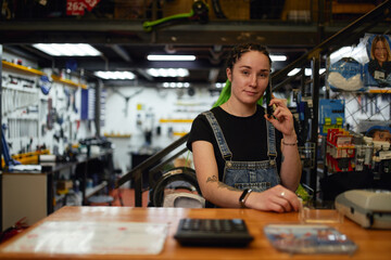 Informal woman speaking on smartphone in garage