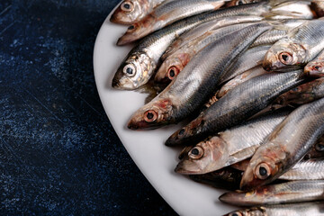 Fresh raw silver herring on a plate.