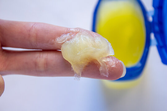 Woman using petroleum jelly for skincare.