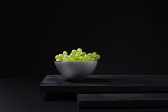 Racimo de uvas para vino blanco Verdejo espa&ntilde;ol en un recipiente sobre fondo negro