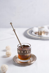 Un vaso de té clásico con dulces chocolates blancos cubiertos de coco en el cuadro blanco	