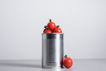 Tomates cherry enteros dentro de una lata de conservas sobre fondo gris	