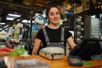 Content saleswoman standing at cash desk in store