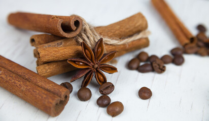 Cinnamon sticks, anise stars and coffee grains, on a gray wooden background close-up 