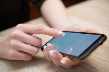 スマートフォンを操作する女性の手