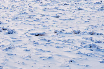 Snow-covered ice of the Amur River in the morning after a blizzard. Fantastic natural landscape without traces of human activity.