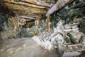 Fototapeta na wymiar Underground gold mine tunnel with wooden timbering