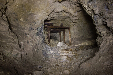 Fototapeta na wymiar Underground gold mine tunnel with wooden timbering