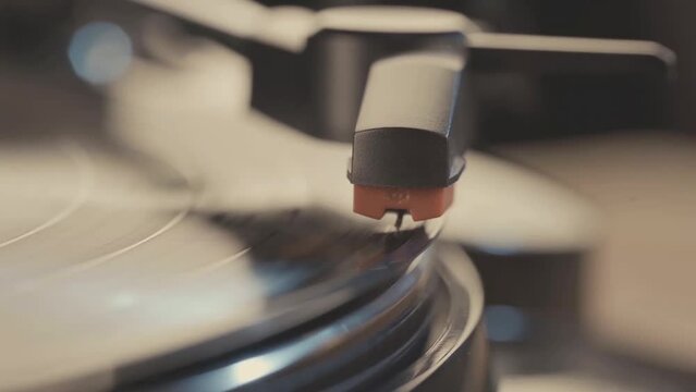 Detail of a woman's hand putting vinyl record into the player