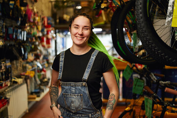 Fototapeta na wymiar Smiling woman with tattoos standing in shop