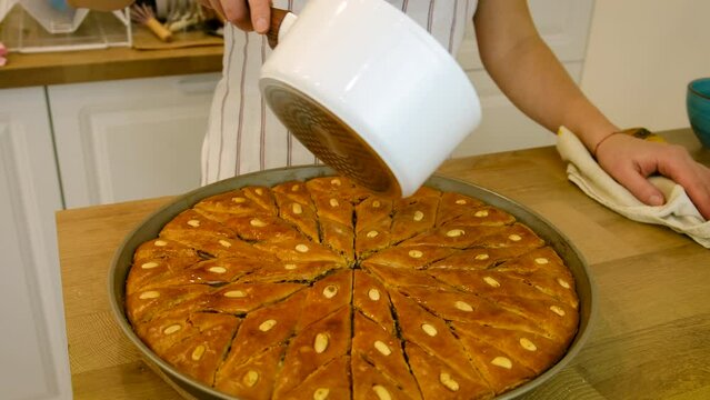 A woman is preparing baklava in the kitchen. Selective focus.