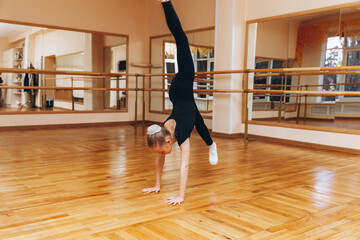 girl gymnast studio. little gymnast performs an exercise on the floor. The concept of sports,...