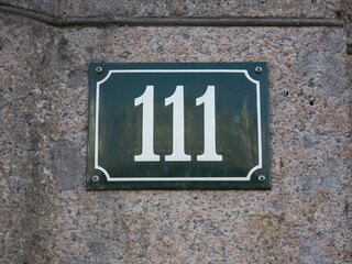 housenumber 111 on an enamel sign on a stone wall - obrazy, fototapety, plakaty