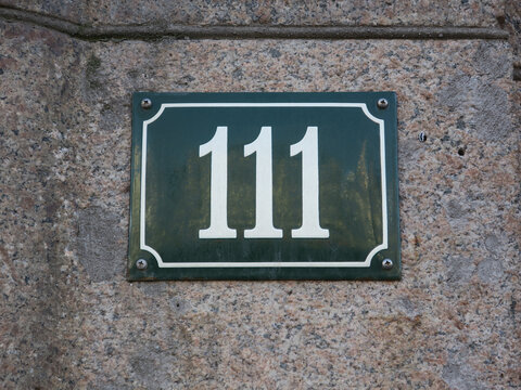 housenumber 111 on an enamel sign on a stone wall