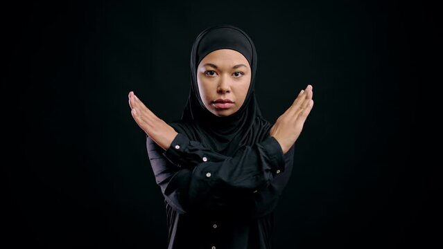 Strong arab woman in hijab showing crossed hands gesture, fight against abuse