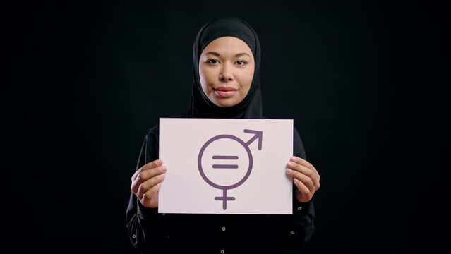 Arab woman in hijab showing gender equality symbol smiling, stop discrimination