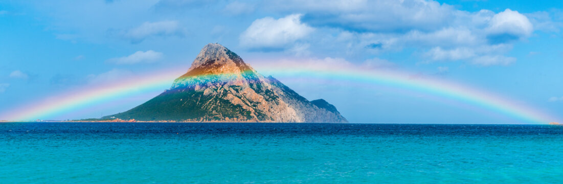Tavolara Island, scenic view of island and full rainbow in a unique moment