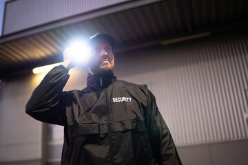 Security Guard Walking Building Perimeter With Flashlight - obrazy, fototapety, plakaty