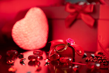 
Valentines day concept. Red hearts,  boxes with valentines gifts and valentines decorations on the glass table.
