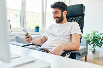 Freelancer using smartphone working at home office