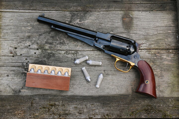 Black powder revolver and cartridges on an old board.