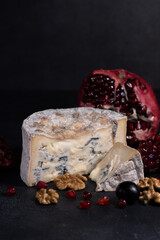 Gorgonzola blue mold cheese with pomegranate, grapes and nuts.