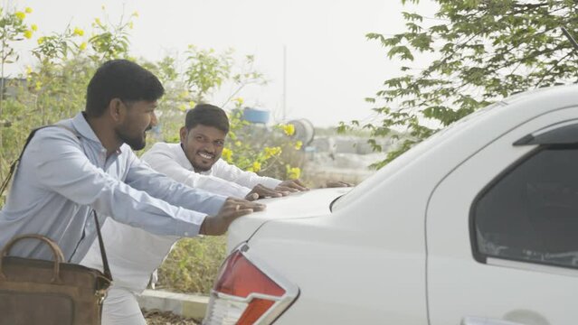 Side view shot of Worried cab driver and passanger pushing the car on roadside - concept of car breakdown, journey, helping hand and transportation
