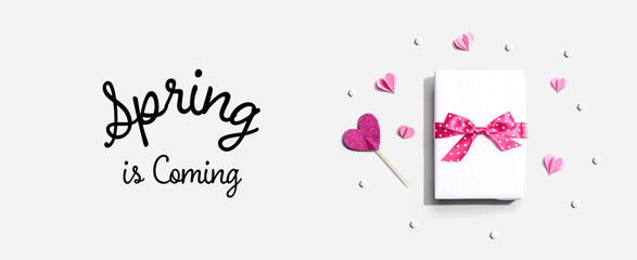 Spring is coming message with a gift box and paper hearts