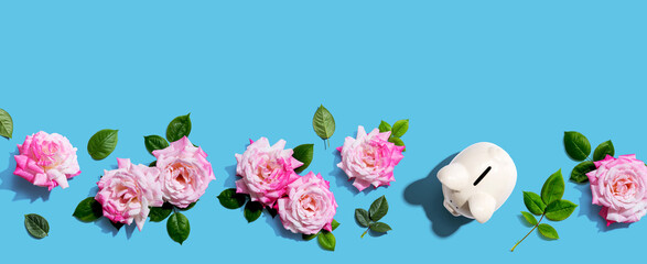 Piggy bank with pink roses overhead view - flat lay