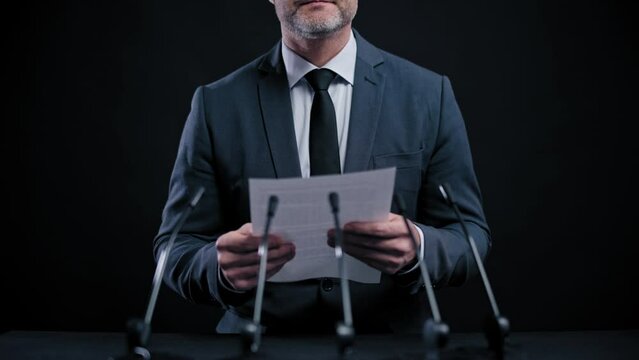 Nervous male speaker reading speech from paper scared of public speaking, stress