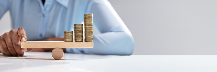 Businesswoman Balancing Stacked Coins With Finger