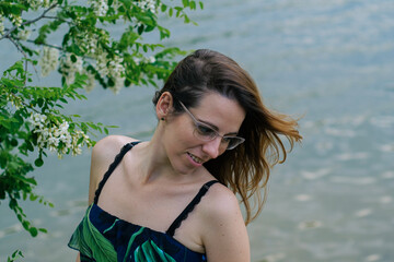 Young woman portrait by the lake and acacia tree in spring