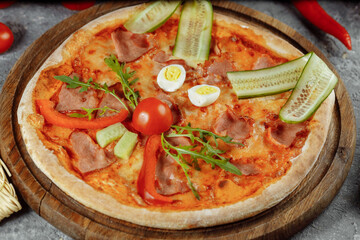Children's pizza in the shape of a cat's face on a white plate, on a white background, top view. Children's menu