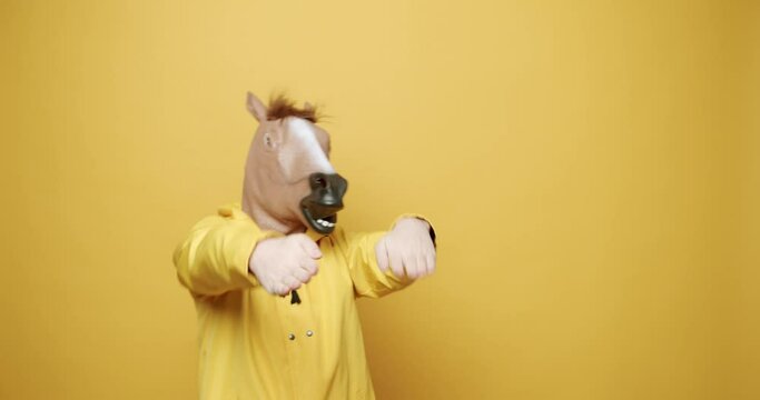 Happy Guy Enjoying Dance with Pigeon Mask on yellow Background. Fool's Day.