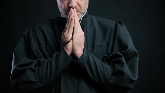 Close-up catholic priest praying with rosary in hands, belief in god, religion