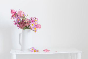 pink flowers in white jug on background  white wall