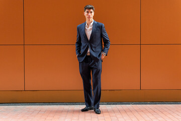 Portrait of a young business man on an orange background. Young entrepreneur concept.