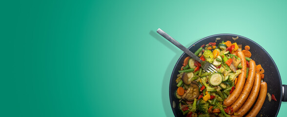 Ceramic frypan with a mix of Mediterranean diet vegetables and sausages, isolated with shadow at turquoise gradient background and copy space for text, details, closeup.
