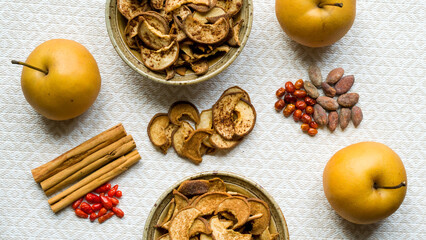 Dried healthy homemade fruit snacks in bowl with two kinds of spices. Asian Pear dehydration, top view.