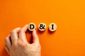D and I, Diversity and inclusion symbol. Concept words D and I, diversity and inclusion on wooden circles on beautiful orange background. Business, D and I, diversity and inclusion concept.